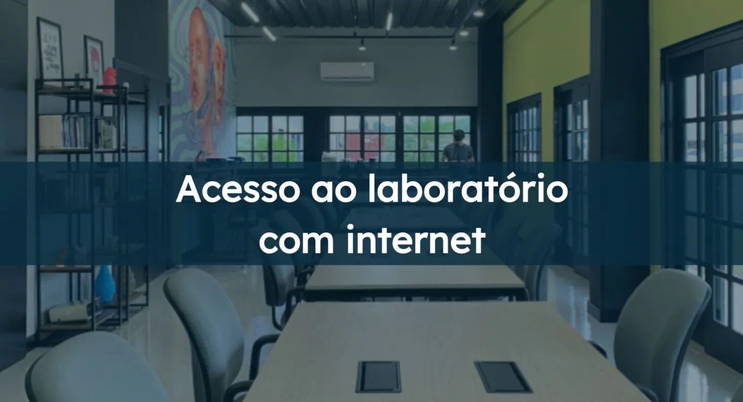 Acesso ao laboratório com internet: área de trabalho do laboratório com mesas longas, cadeiras e um mural colorido