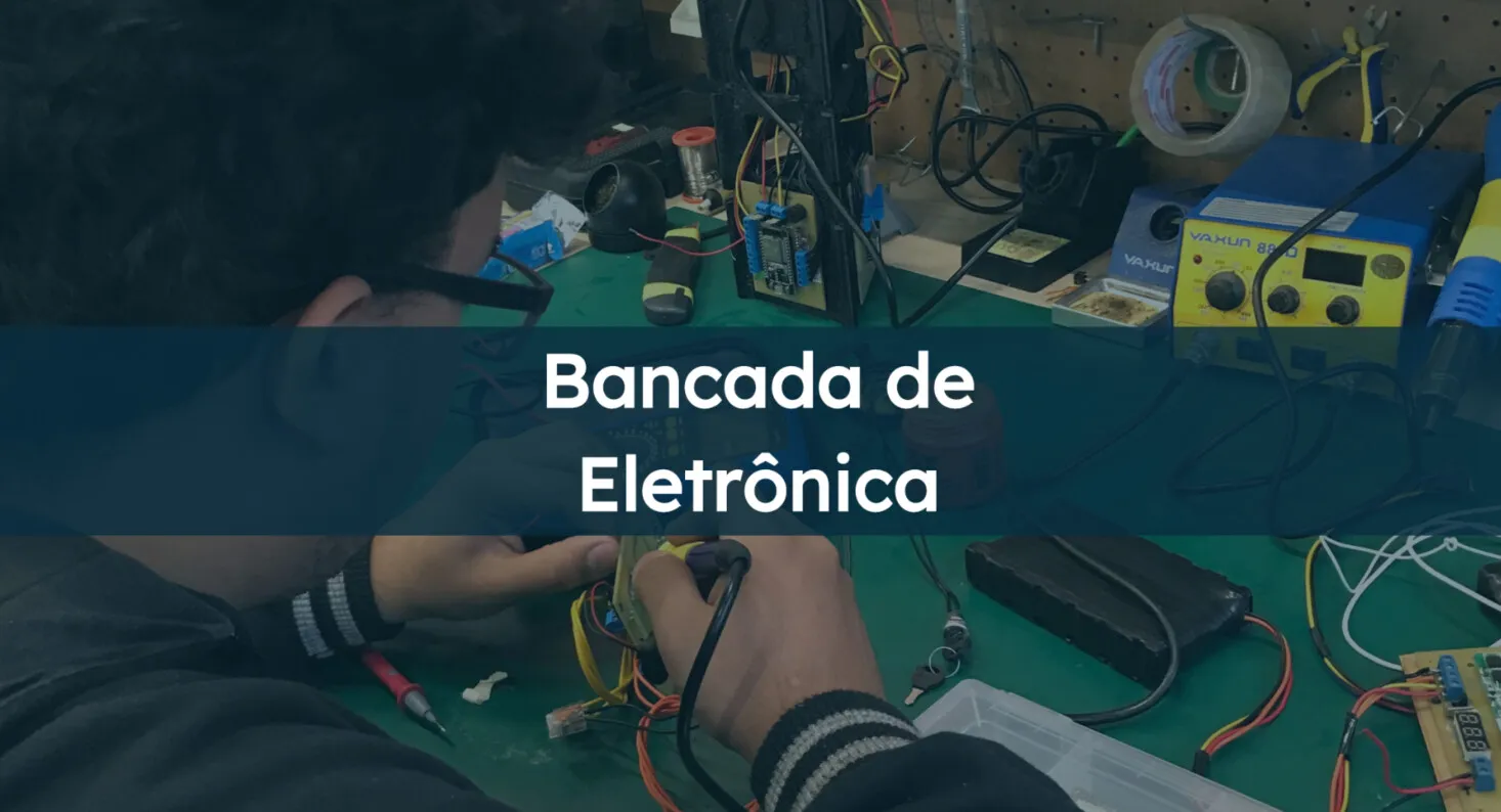 Bancada de Eletrônica: pessoa soldando uma placa ao lado de uma estação de solda